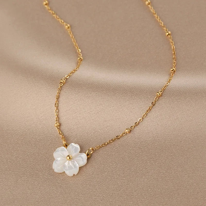 Gold-tone chain necklace with white five-petal pearl flower pendant