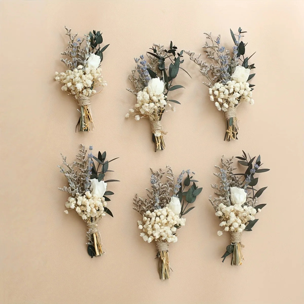 Set of 6 dried flower boutonnieres with white baby’s-breath blooms and green leaves
