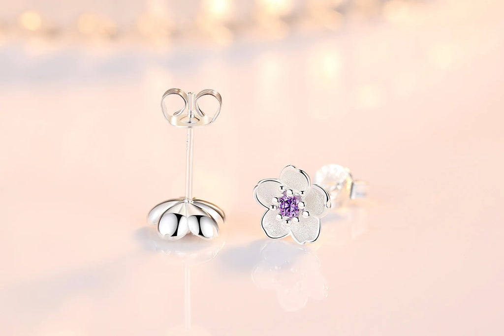 Silver-tone flower stud earrings with purple zircon center stones and butterfly back closures