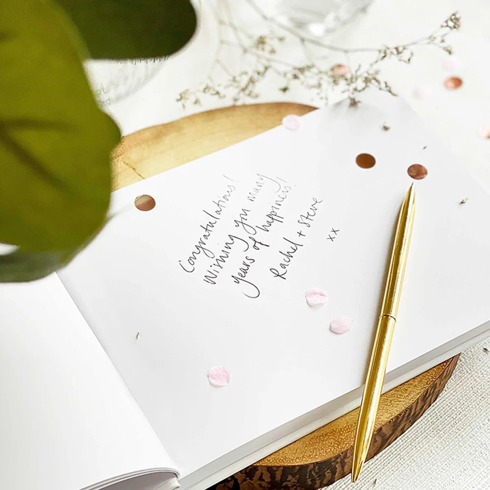 Wedding guest book page with handwritten note-style couple names on white cover