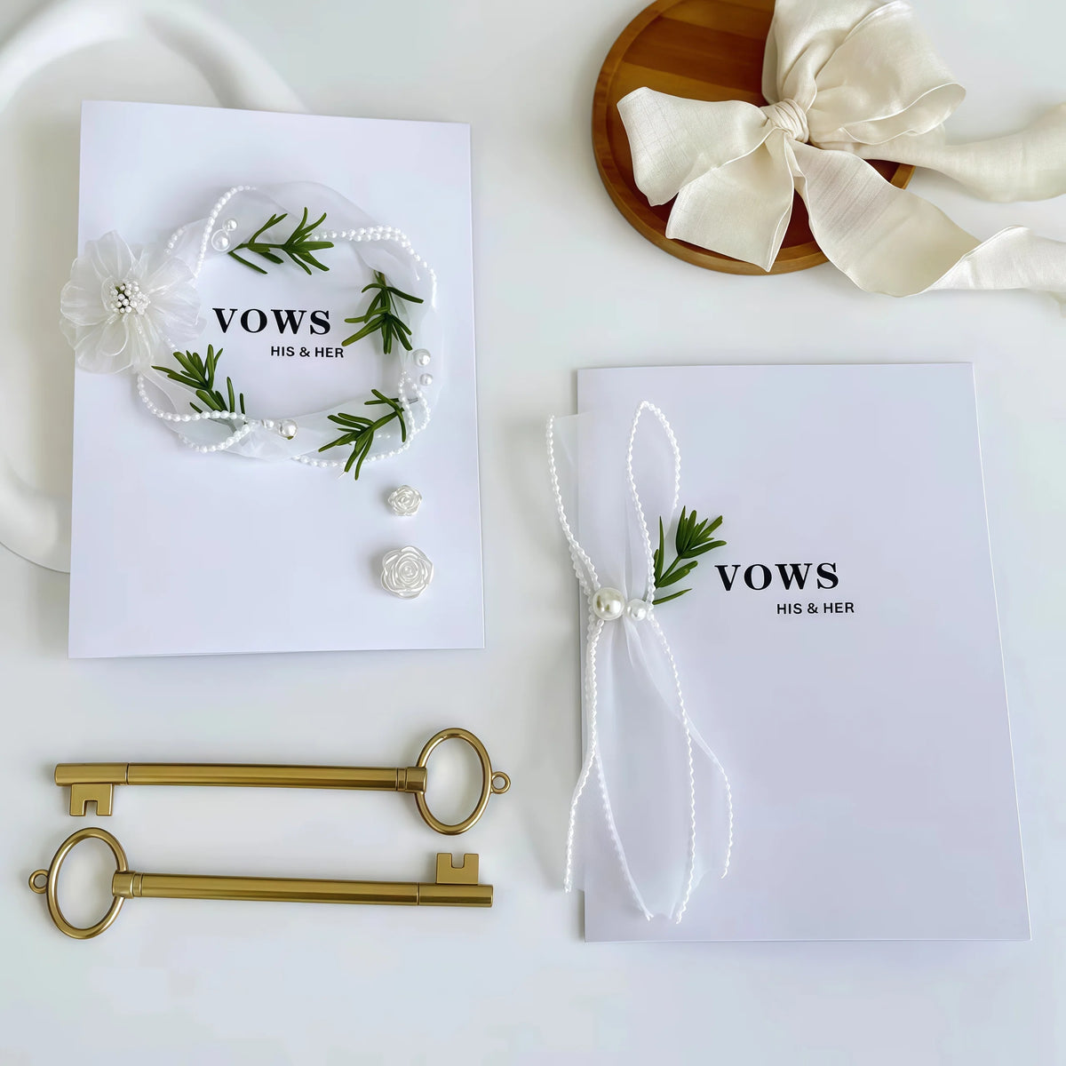 White wedding vow booklets with 'vows' text, green wreath heart, pearl strings, and ribbon bows