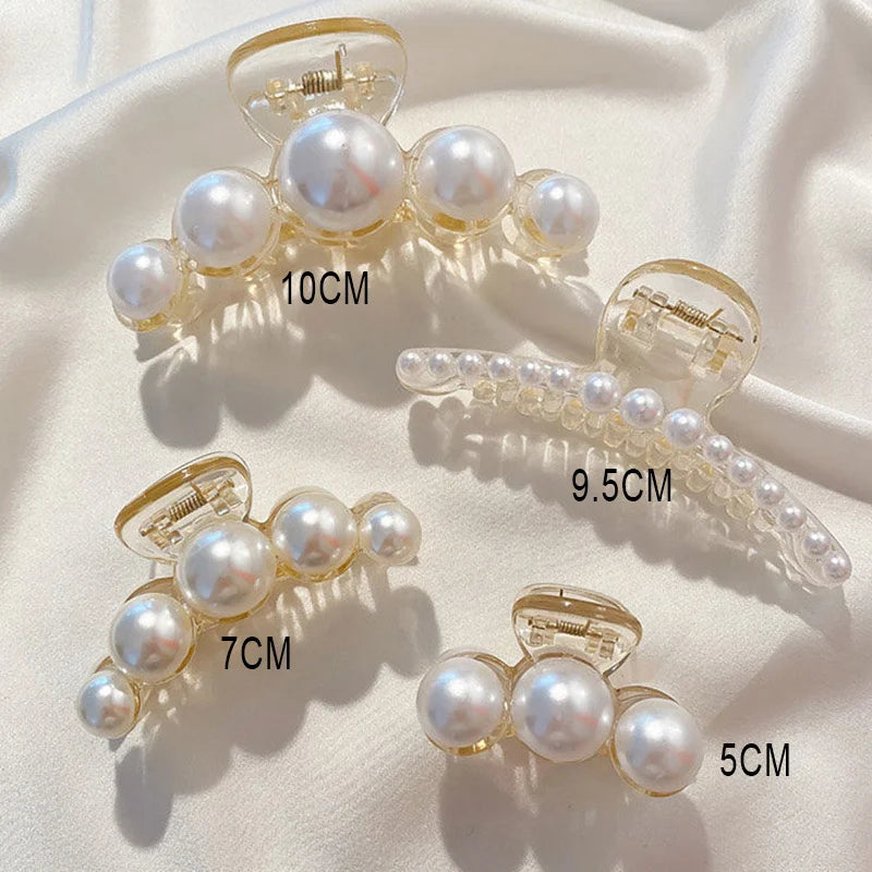Assorted pearl claw clips with gold-tone frames and white faux pearls; ~10cm, ~9.5cm, ~7cm, ~5cm.