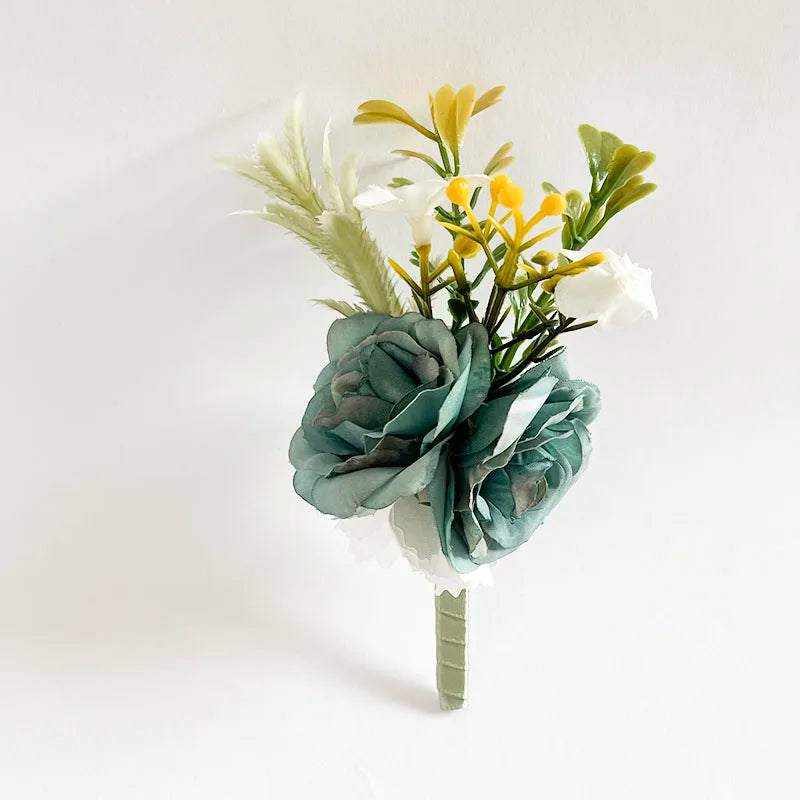 Silk rose boutonniere with teal blooms, yellow sprigs, and white accents