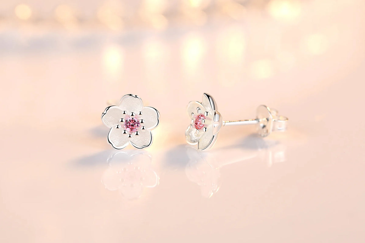 Silver-tone flower stud earrings with pink zircon center stones and butterfly back posts