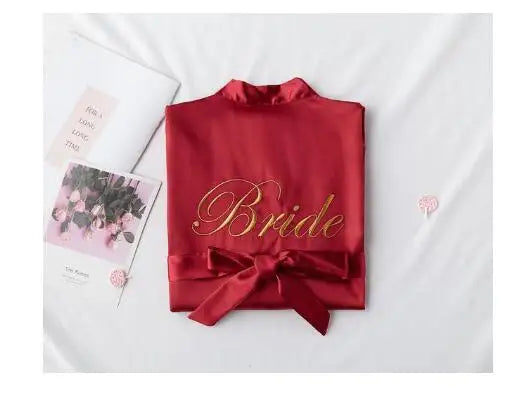 Red satin robe with embroidered “Bride” on chest and bow at the waist