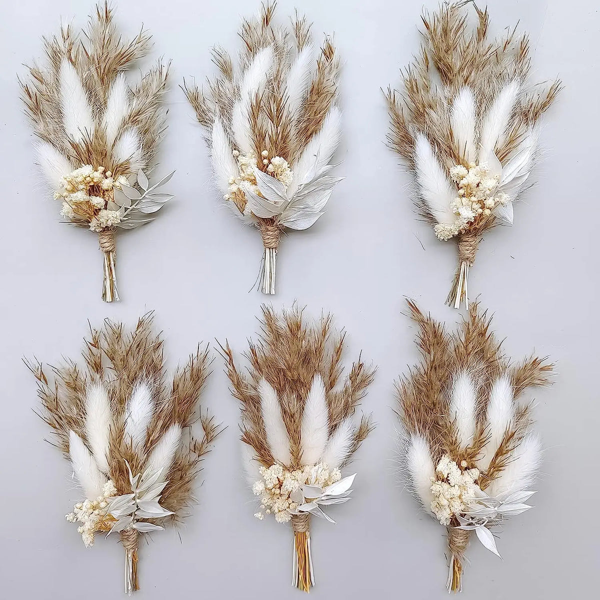 Six dried flower boutonnieres with wheat plumes, white blossoms, and tan/orange accents