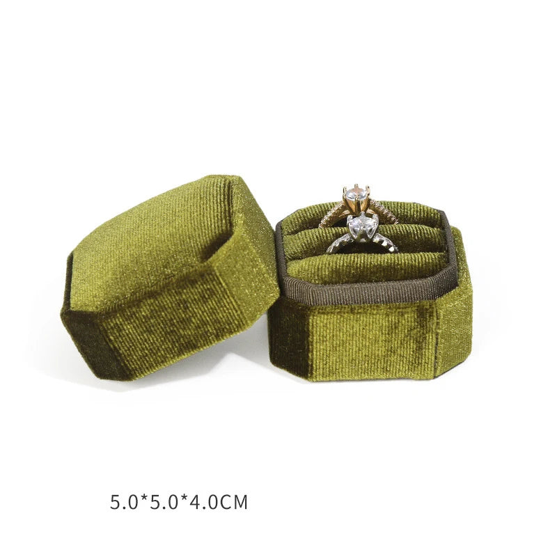 Olive octagonal velvet ring box open with an engagement-style ring and size text