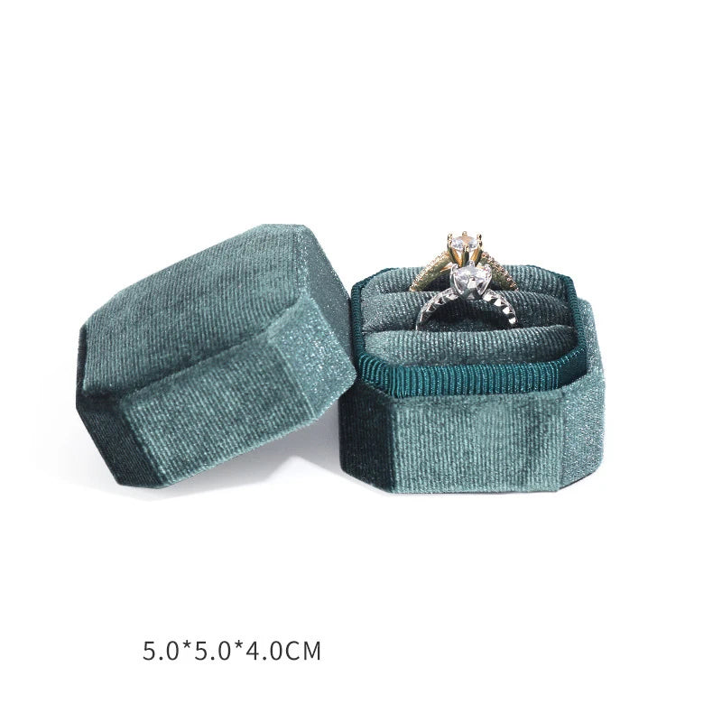 Teal octagonal velvet ring box open with a diamond-style ring and size text