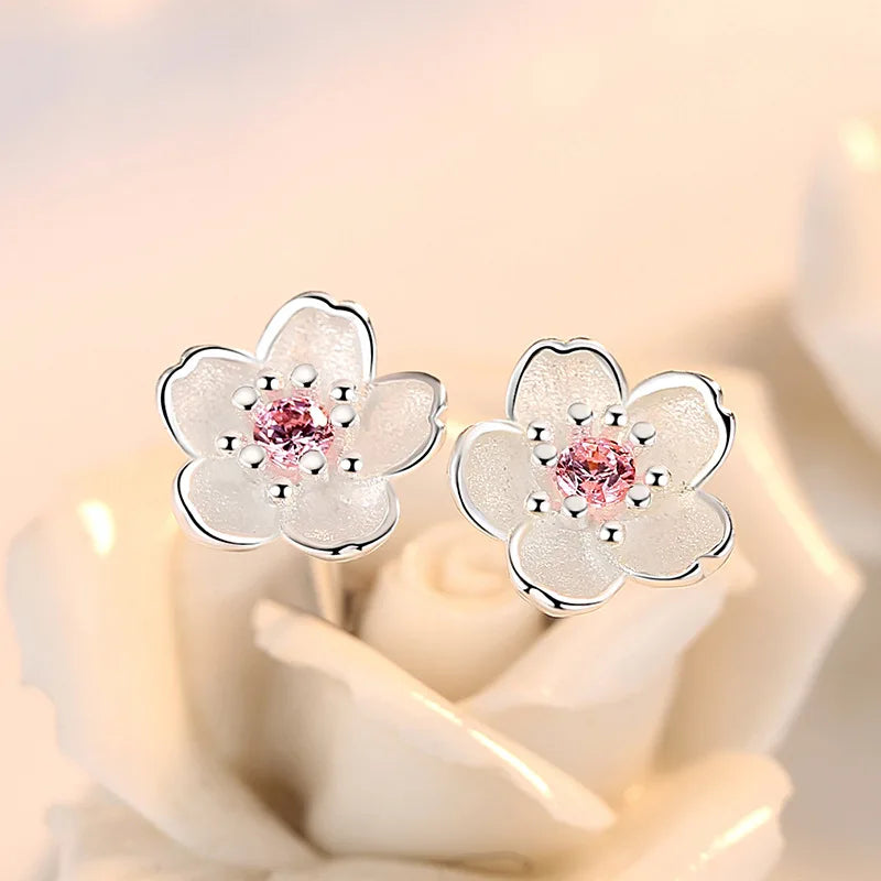 Silver-tone flower stud earrings with pink zircon center stones and tiny clear accents