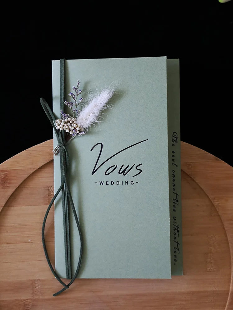 Sage wedding vows booklet with feather and pearl floral decoration and ribbon loop