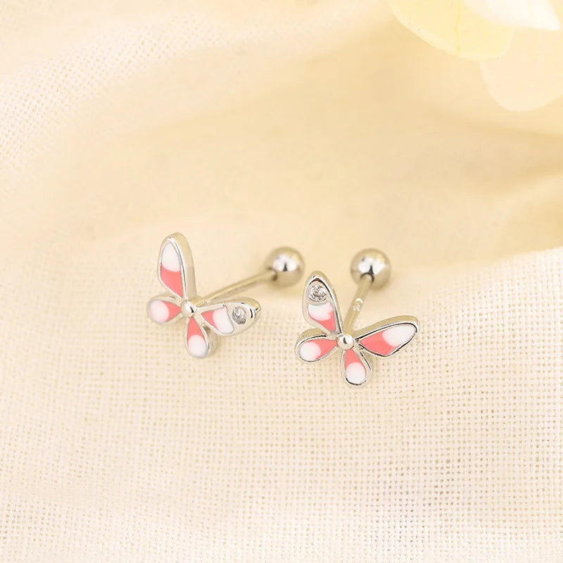 Gold-tone huggie hoop earrings with pink butterfly crystal charms
