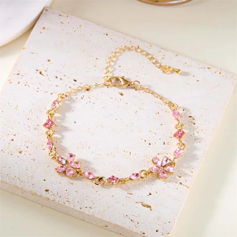 Gold-tone crystal flower bracelet with pink petal charms