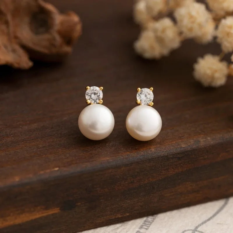 Freshwater pearl stud earrings with sparkling stone top, gold-tone setting