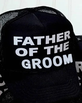 Black mesh trucker cap with bold white text: FATHER OF THE GROOM