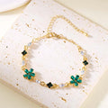Gold-tone crystal bracelet with green flower charms and clear teardrop stones