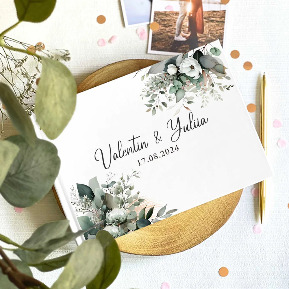Wedding guest book cover featuring eucalyptus greenery, white blooms, and couple names with date