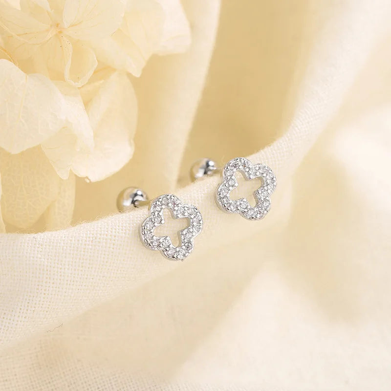 Silver huggie hoop earrings with four-petal crystal clover charm and round ball posts