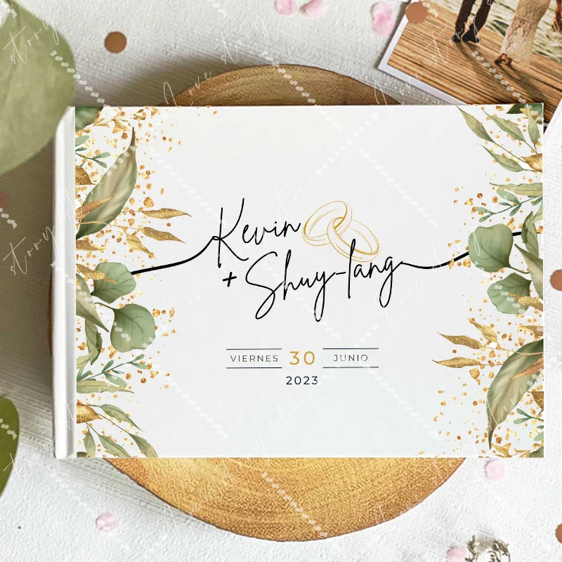 Wedding guest book cover with gold foil style typography and small confetti leaf accents