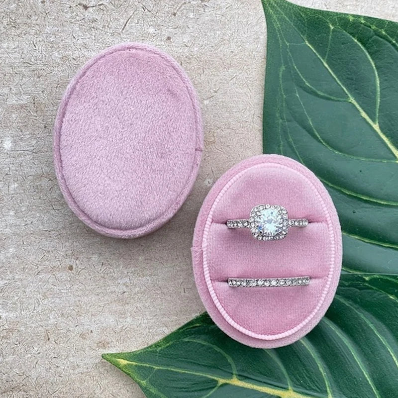 Light purple velvet ring box with gemstone-style ring and slim band