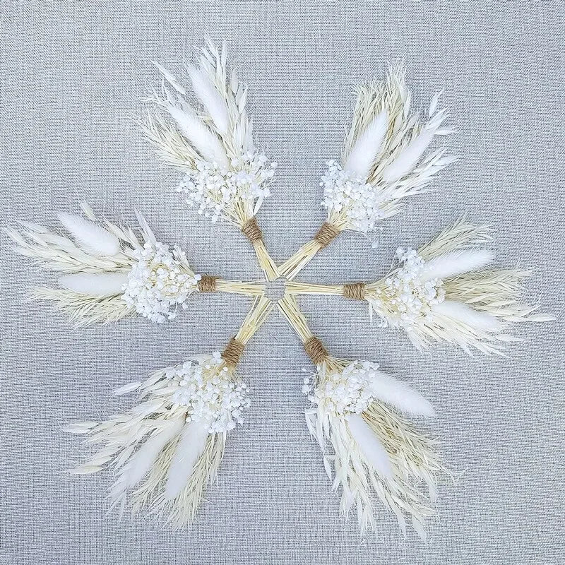 Star-shaped display of white dried flower boutonnieres with twined stems and blossoms