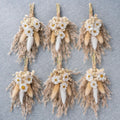 Set of tan dried flower boutonnieres with white daisies, fluffy pampas plumes, and straw stems