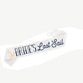White sash with navy script 'Bride's Last Sail' and gold anchor emblem