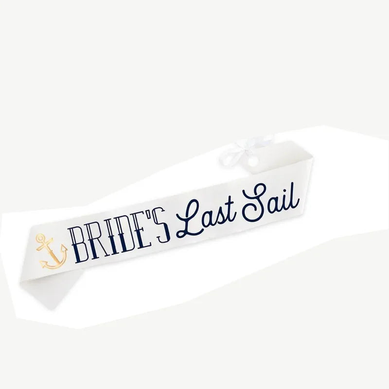White sash with navy script 'Bride's Last Sail' and gold anchor emblem