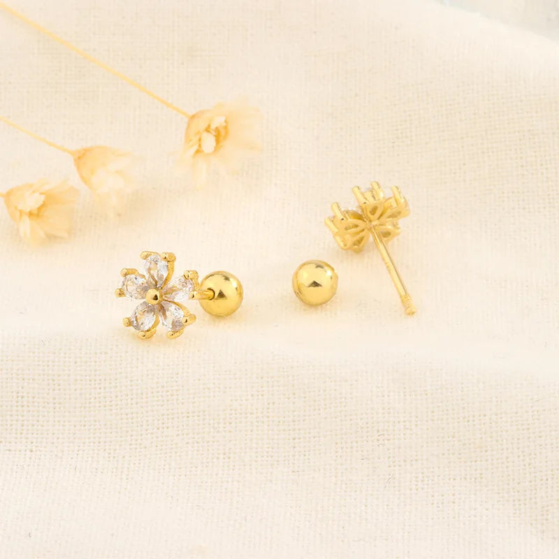 Gold-tone stud earrings with small flower and snowflake designs