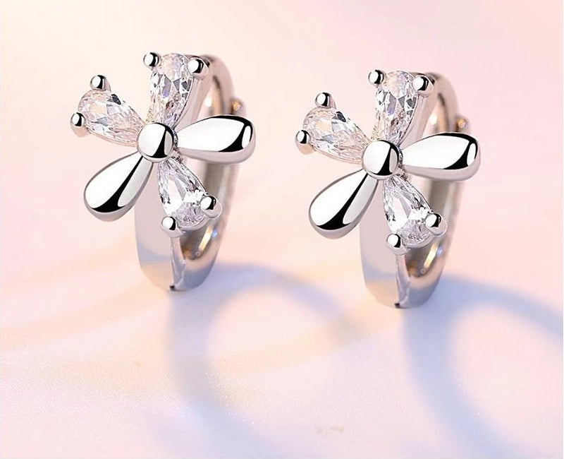 Silver-tone crystal flower hoop earrings with bow-like petals and clear stones