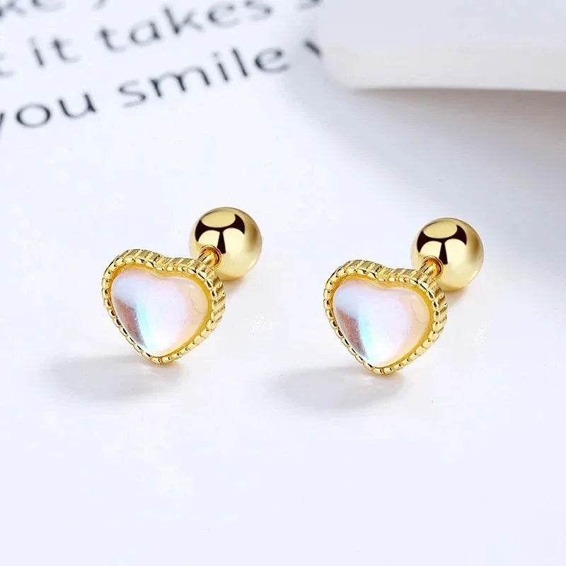 Gold-tone huggie hoop earrings with heart-shaped opal-like crystal drops