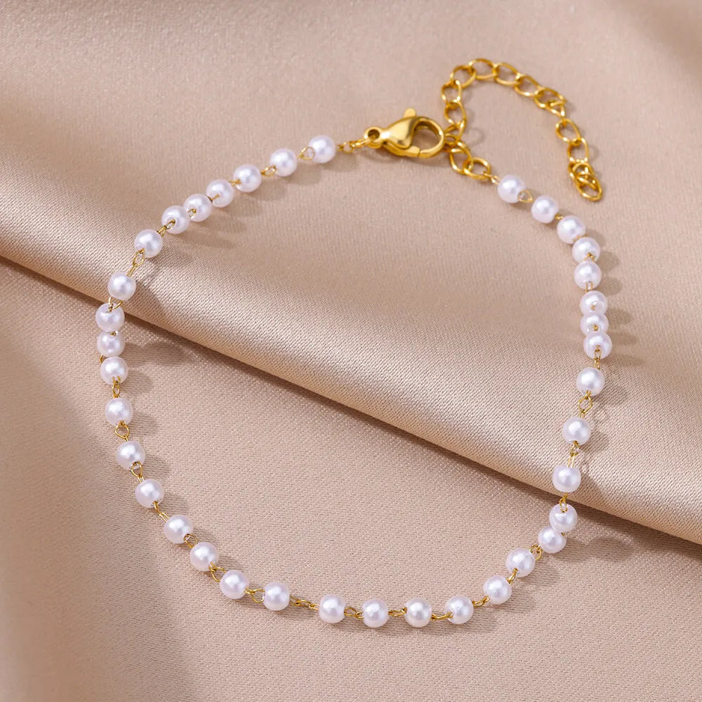 Gold-tone pearl bracelet with evenly spaced small pearls and heart toggle clasp