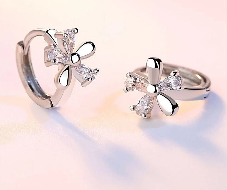 Silver-tone crystal flower hoop earrings with multi-petal design and clear stones