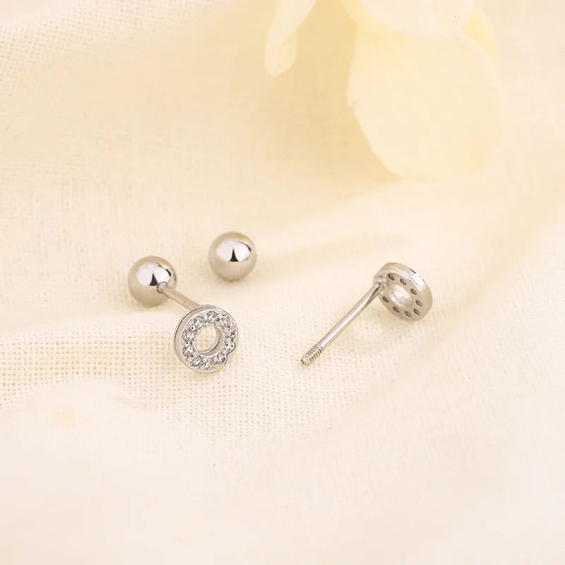 Small silver-tone huggie hoop earrings with round crystal motif and back posts