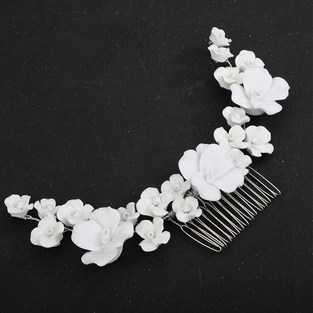 Bridal orchid hair comb with white blossoms and silver-tone prongs, angled view