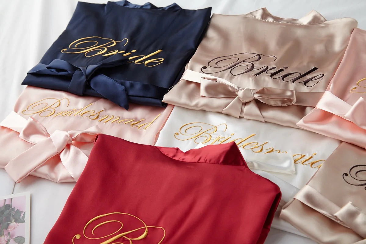 Satin bridal robe set with ribbon bows, navy “Bride” and blush “Bride”