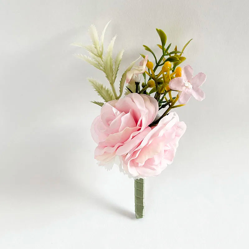 Silk rose boutonniere with pink flowers, greenery, and wrapped stem