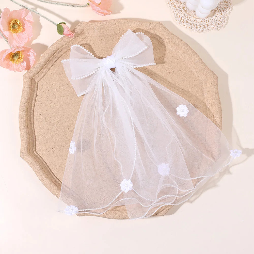 White pearl-edged tulle bow hair clip with flowing veil layers