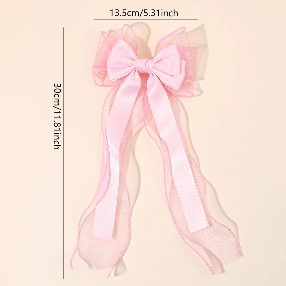 Pink chiffon bow hair clip with long ribbon streamers and soft mesh loops