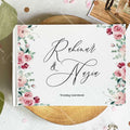 Wedding guest book cover with pink rose corners and large script names; Wedding Guestbook