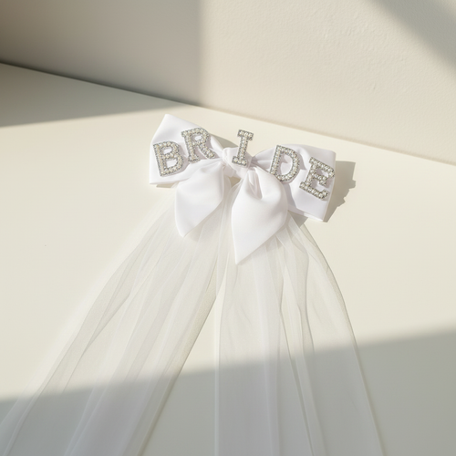 Bride-to-be pearl veil with rhinestone “BRIDE” headband and large white bow, layered tulle