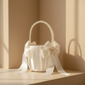 Ivory satin flower girl basket with pearl beaded handle and bow, ribbon streamers hanging