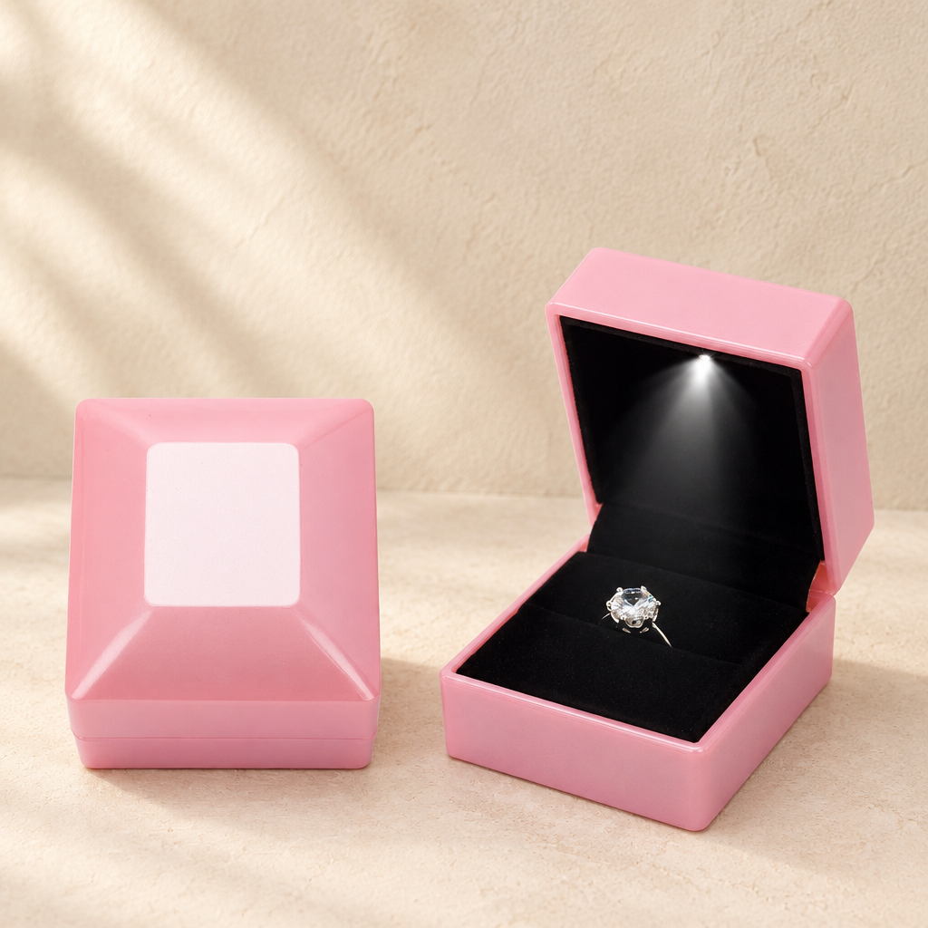 Pink LED proposal ring box with open lid and ring on black velvet insert.