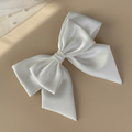 Satin white double bow hair clip with layered ribbon loops and pointed ends
