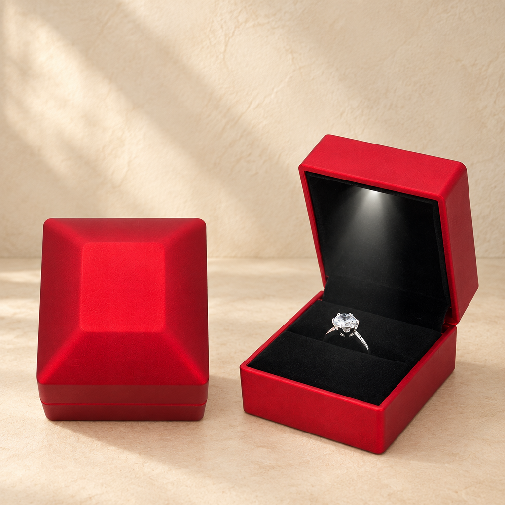 Red LED proposal ring box with open lid and ring on black velvet insert.