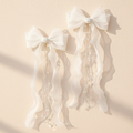 White tulle hair bow with faux pearl tassels and dangling bead strands, flower girl clip